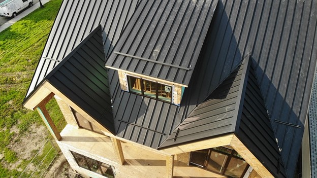 View of a house with a black metal roof.