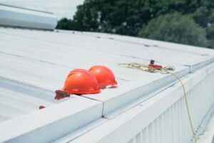 Two orange helmets on a metal roof.