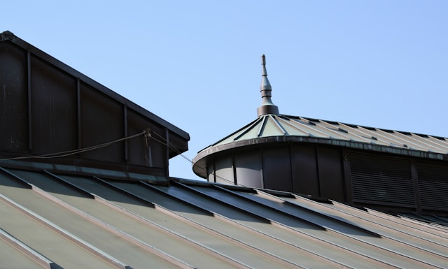 Metal roofs with a stylish spire against a blue sky